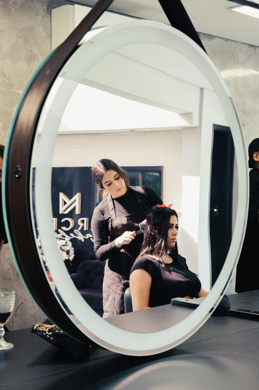Person styling their hair in a bathroom mirror